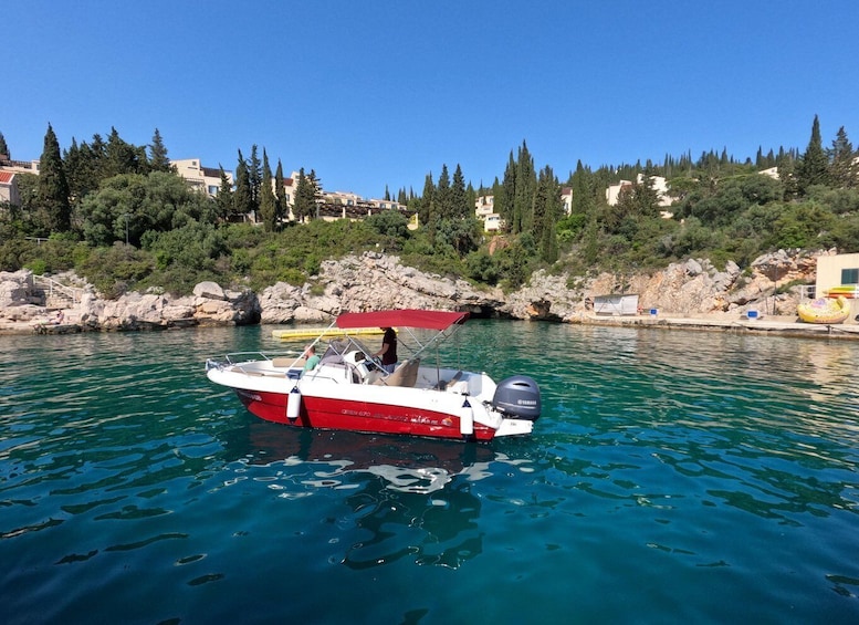 A red and white boat with a Yamaha outboard motor on calm, turquoise water. 1