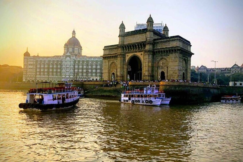 A river with boats, a large building with a dome, and a stone gateway. 1