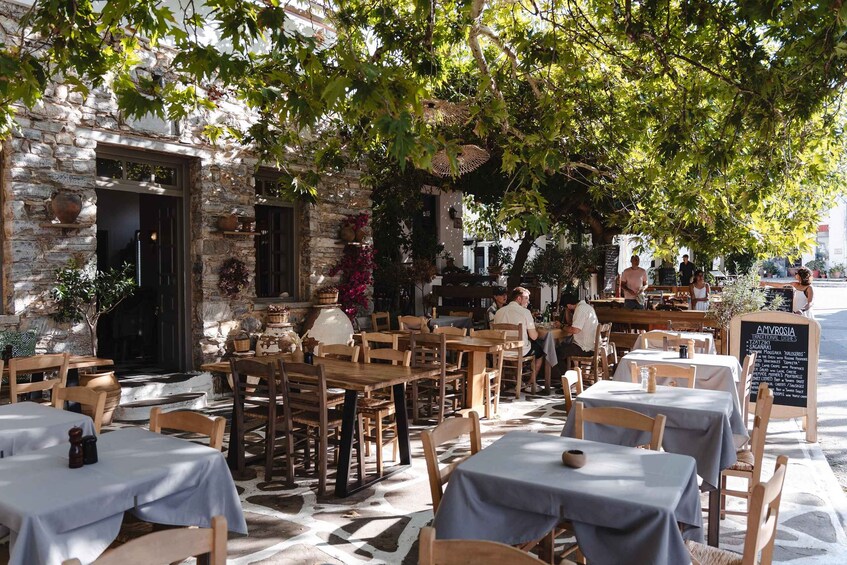An outdoor cafe with stone walls and wooden tables. 3