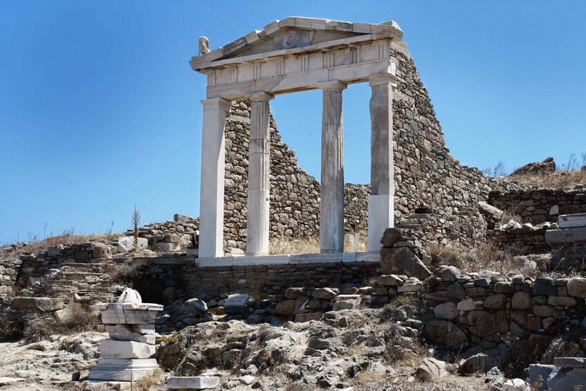 An ancient Greek temple with columns and stone ruins. 3