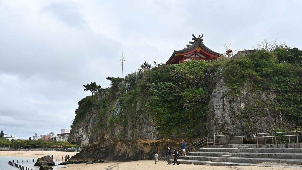 A traditional Chinese temple on a cliff overlooking a beach. 4