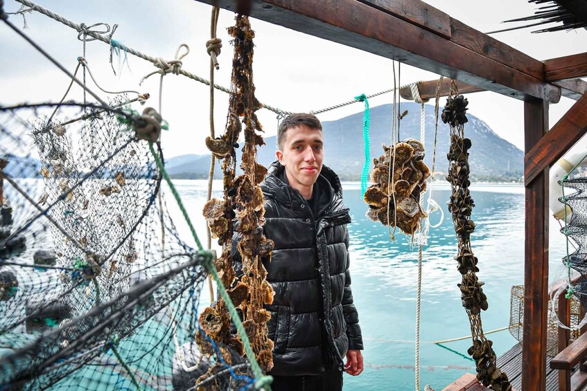 A person standing on a boat with fishing nets and ropes. 2
