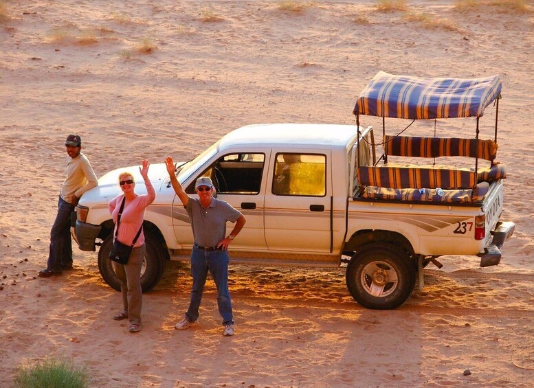 A desert landscape with a pickup truck parked on sandy terrain. 4