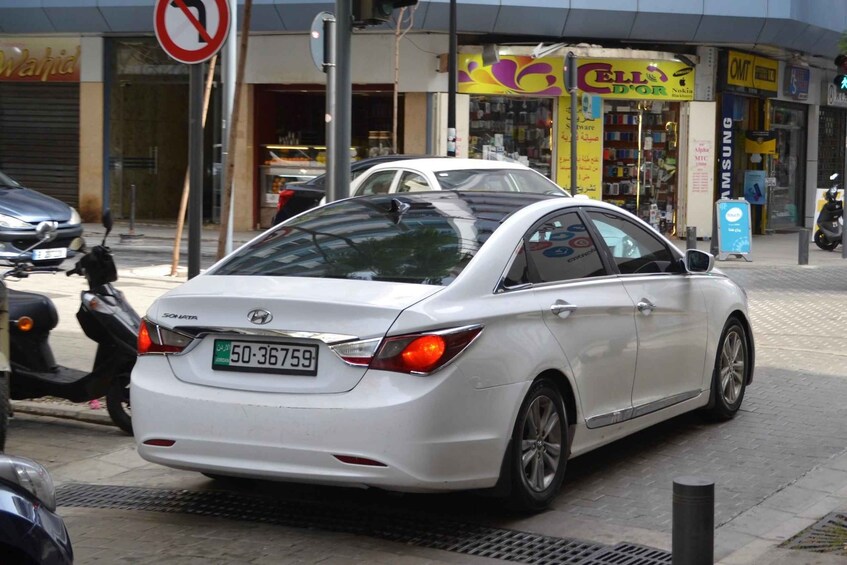 A white Hyundai Sonata parked on a city street. 3