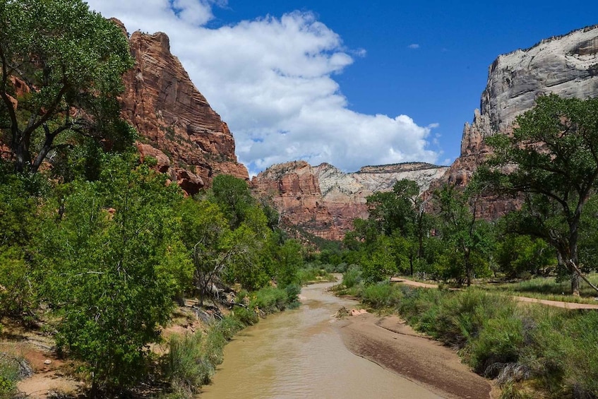 A river winding through a canyon with red rock cliffs and green vegetation. 2
