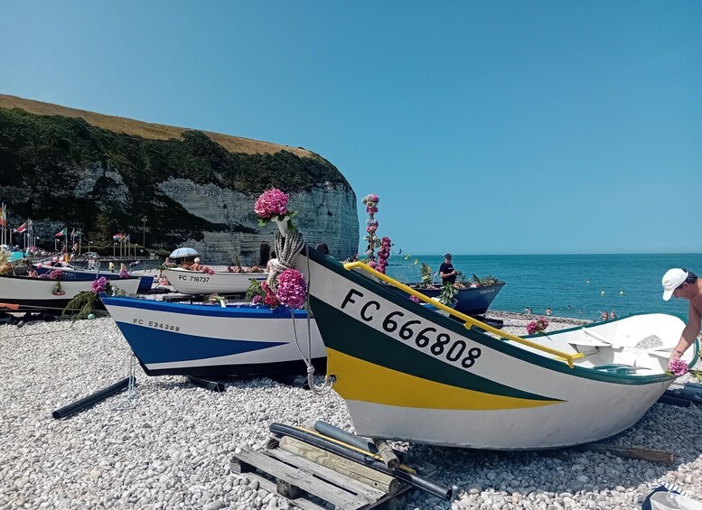 A beach with boats docked, cliffs in the background, and clear blue water. 3