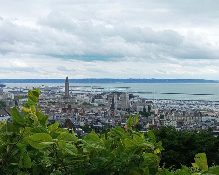 A coastal cityscape with a prominent tower, dense urban buildings, and a body of water in the background. 4