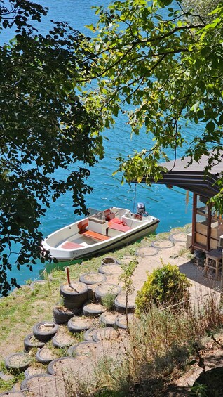 A small boat docked at a pier with a wooden structure nearby. 2