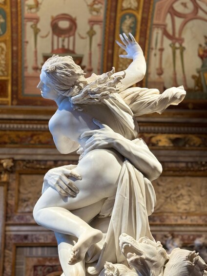 A marble sculpture of a woman in flowing drapery, with a horse and a lion. 2