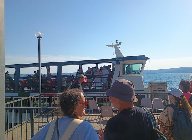 A boat with passengers, a clear sky, and a calm sea. 3