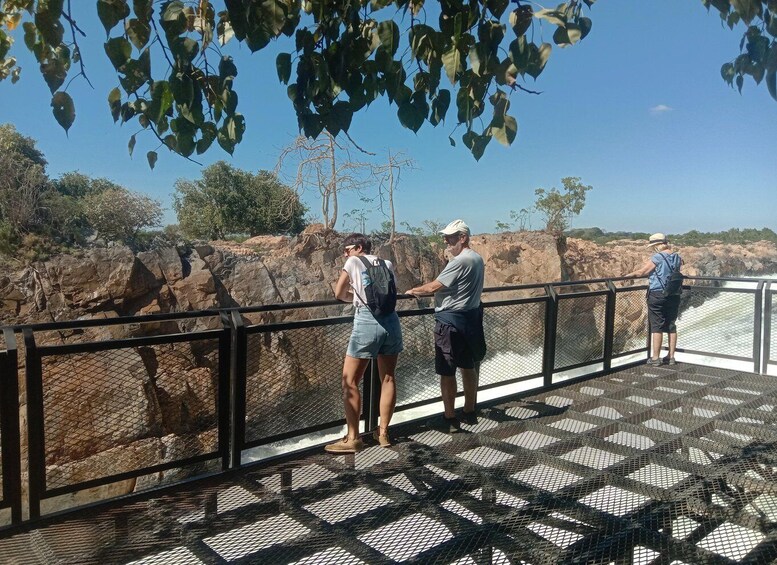 A bridge with a metal mesh floor overlooking a rocky landscape. 2