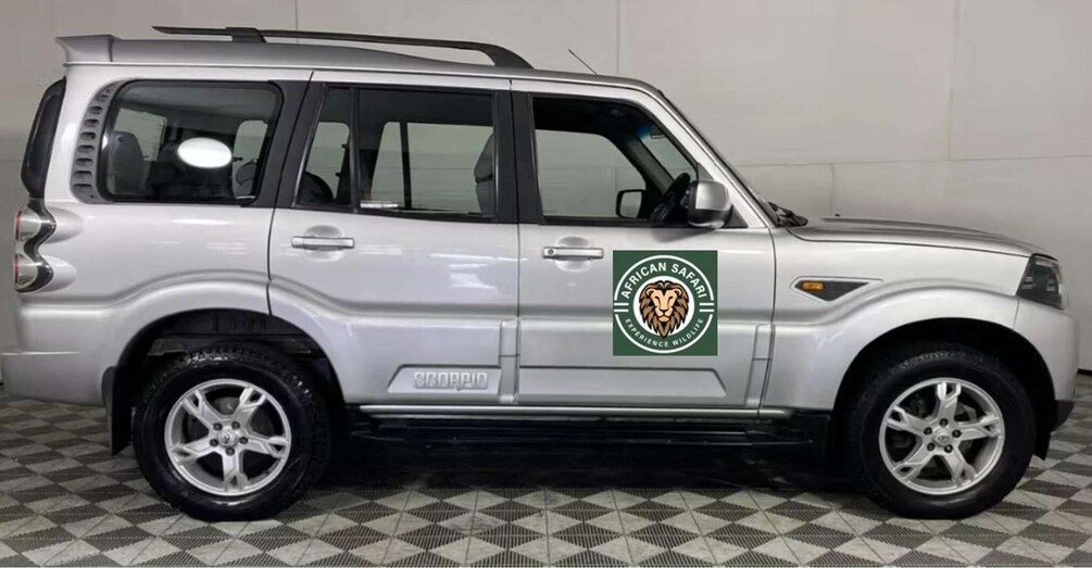 A silver SUV with a logo for 'African Safari Experience Wildlife' on the side. 1