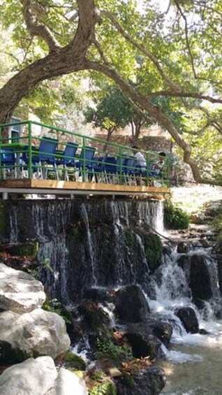 A waterfall with a viewing platform and chairs. 3