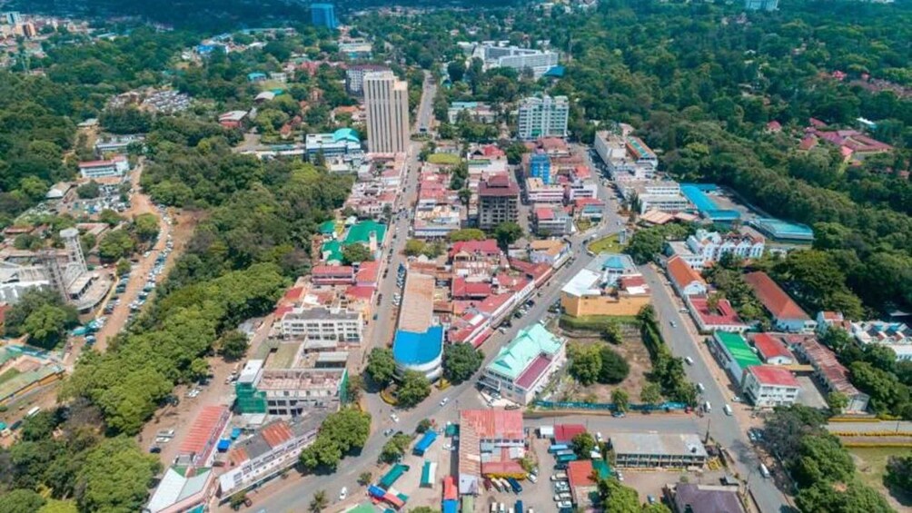 An aerial view of a city with dense urban development, green spaces, and a mix of residential and commercial buildings. 3