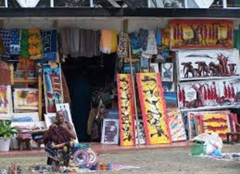 A street market with colorful textiles and a person selling items. 2
