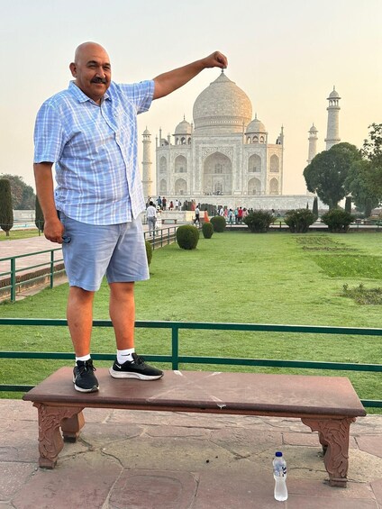 Mies seisoo penkillä, ja taustalla näkyy Taj Mahal. 4