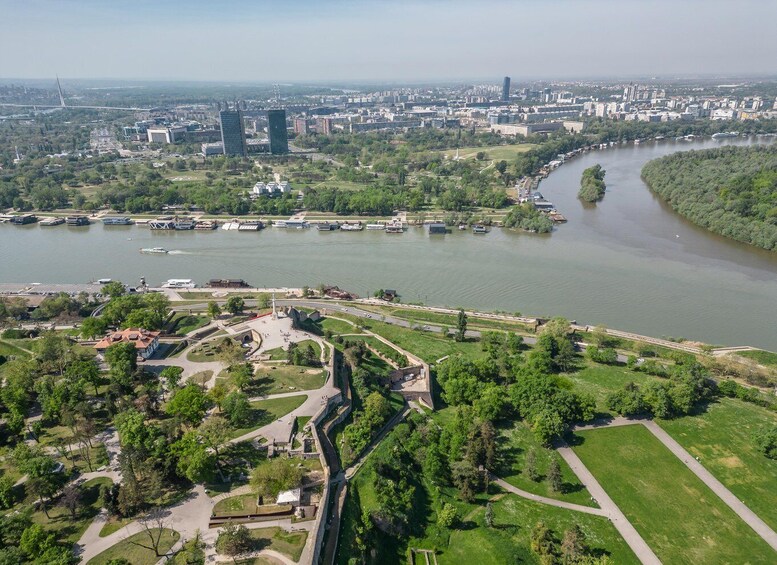 An aerial view of a city with a river, green parks, and modern buildings. 1