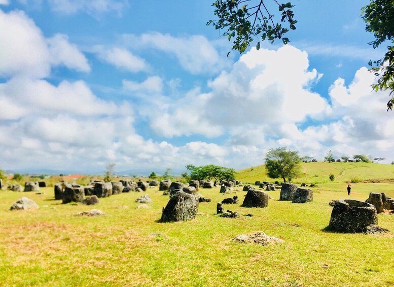 A field of standing stones under a partly cloudy sky. 3