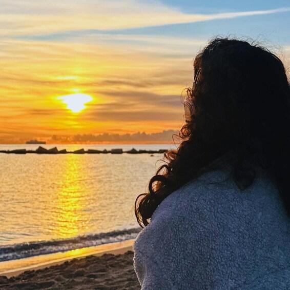 A person facing a sunset over a body of water. 3