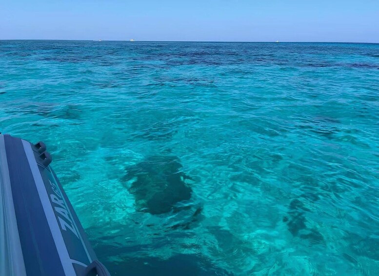 A boat on turquoise water with clear visibility to the ocean. 3