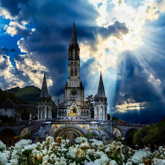 A Gothic-style cathedral with two spires, surrounded by lush greenery and a dramatic sky. 4