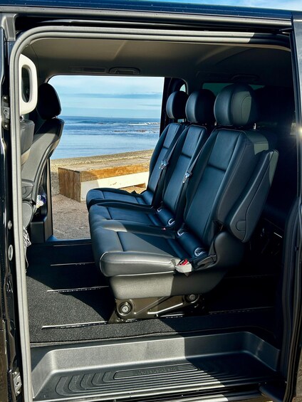 A Mercedes-Benz van with a beach view through the open door. 5