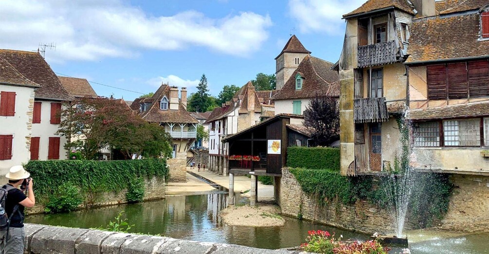 A narrow waterway flanked by historic buildings with steep roofs and wooden shutters. 2