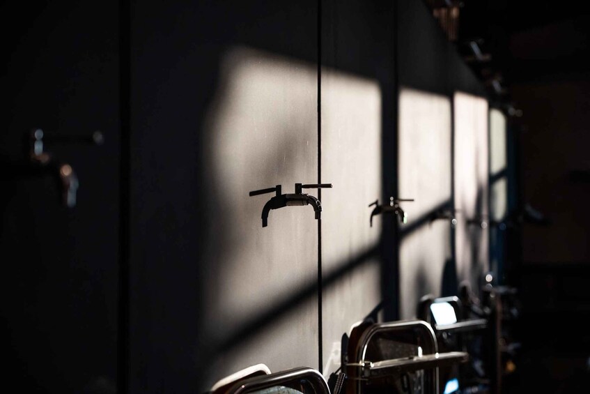 A row of bicycles parked against a wall with a shadow cast by a window. 4