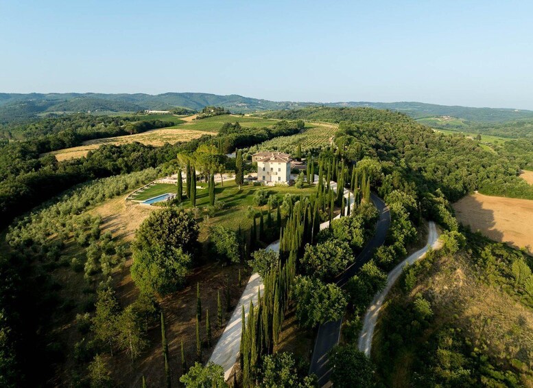 A large estate surrounded by lush greenery and rolling hills. 1