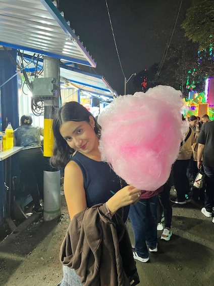 A person holding a large pink cotton candy. 5
