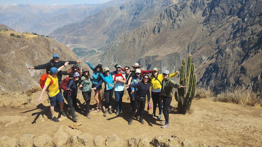 Een groep wandelaars op een bergpad, met een cactus op de voorgrond. 5
