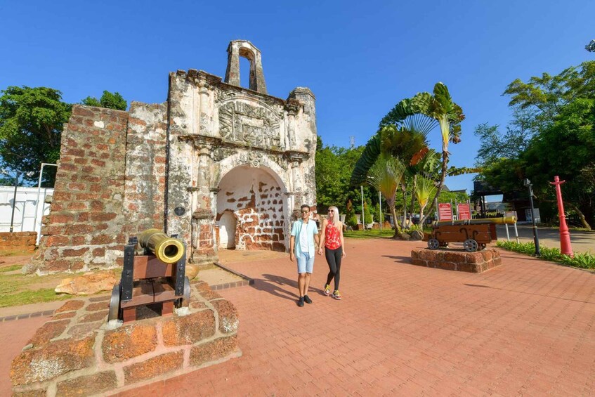 A historical fort with a cannon, a red brick pathway, and lush greenery. 1