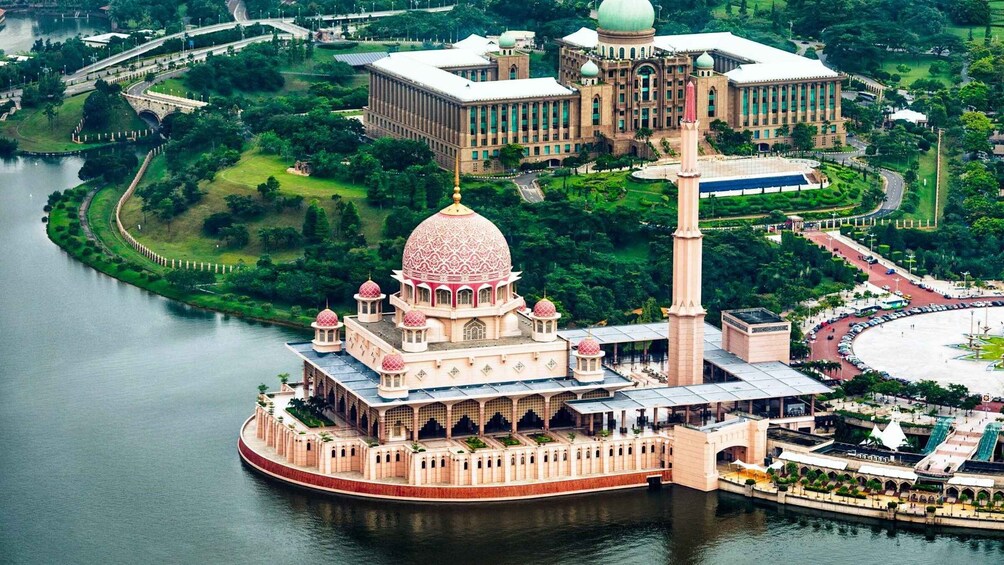 A large, ornate building with a central dome and minarets, surrounded by water and greenery. 4