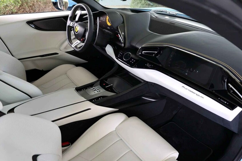 A luxury car interior with a black and white color scheme, a digital instrument cluster, and a central console with a gear shift. 3