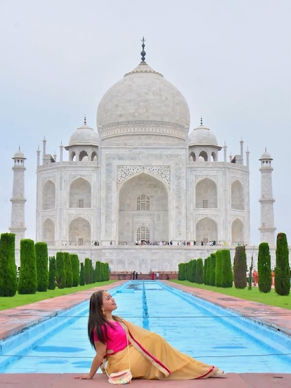 A person lying on the ground in front of the Taj Mahal. 1