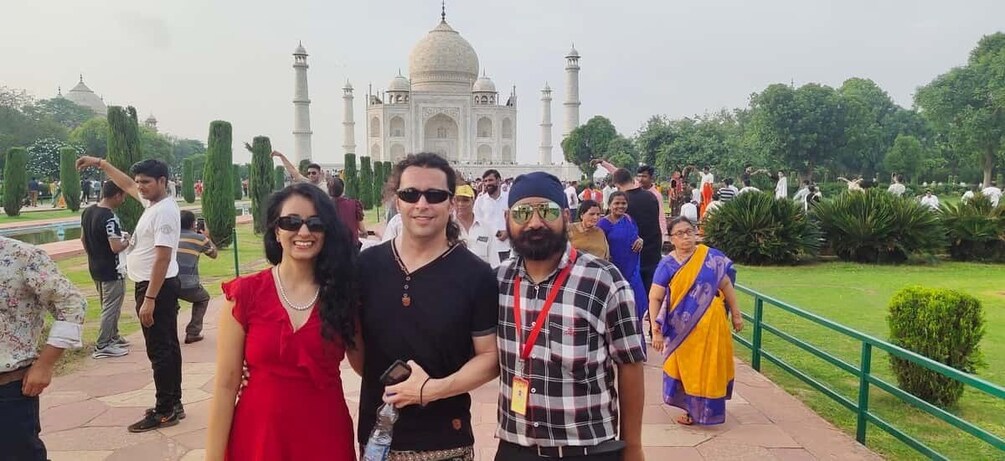 A group of people standing in front of the Taj Mahal. 4