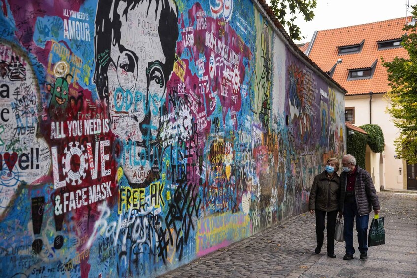 A colorful graffiti-covered wall with various messages and a large portrait of a woman. 2