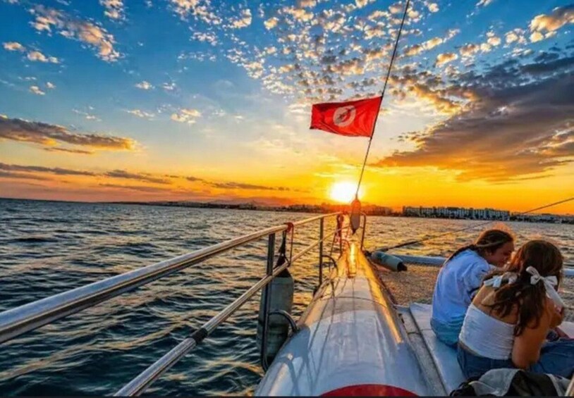 A sunset over the water with a flag on a boat. 4