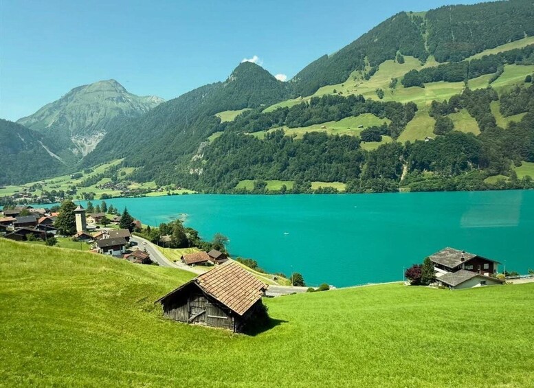 A lake surrounded by green hills and houses. 5