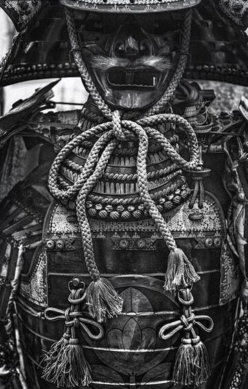 A detailed statue with intricate designs and ropes tied around its chest. 3