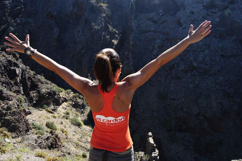 A person with arms outstretched in a mountainous area. 2
