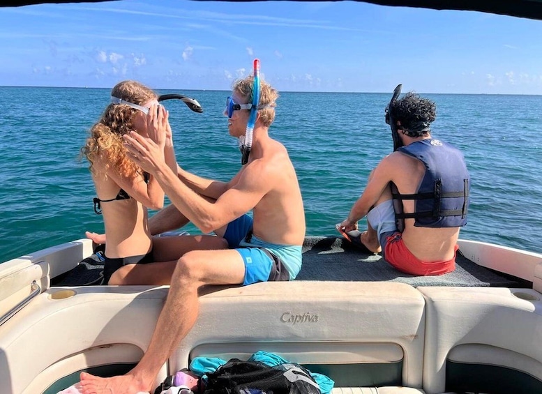Three people on a boat with the ocean in the background. 1