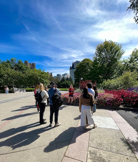 A group of people standing on a paved area with a clear sky and trees in the background. 3