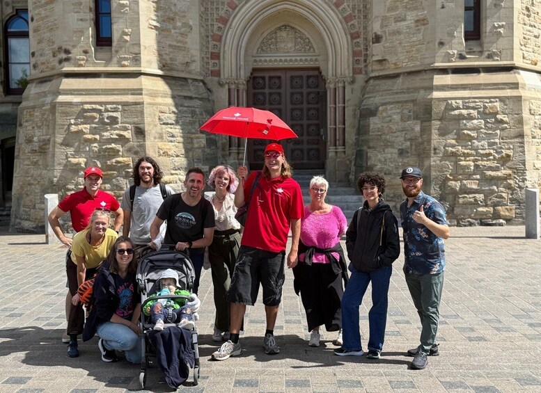 A group of people in front of a stone building with an arched entrance. 1