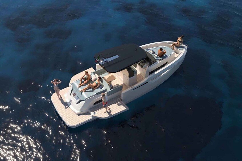 A yacht with a covered deck and passengers enjoying the water. 1