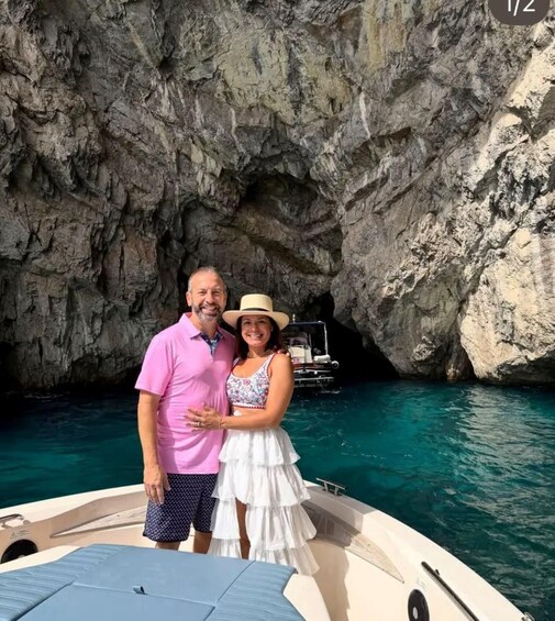 A couple on a boat near a rocky coastline. 3