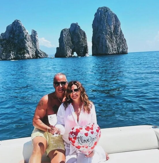 Two people on a boat with a heart-shaped balloon and a bottle of champagne. 5