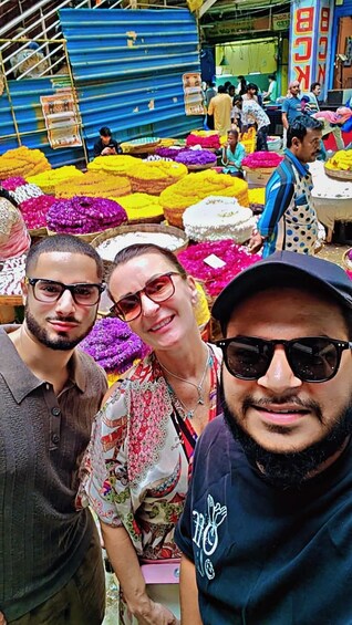 A market with colorful flowers and people shopping. 5
