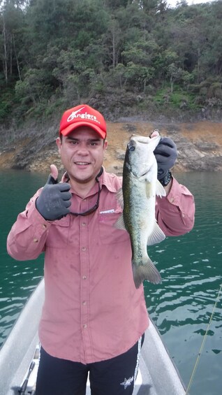 A person holding a fish on a boat. 1