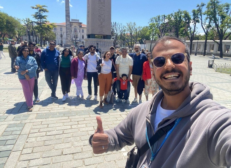 A group of people standing in a public square with a tall monument in the background. 4